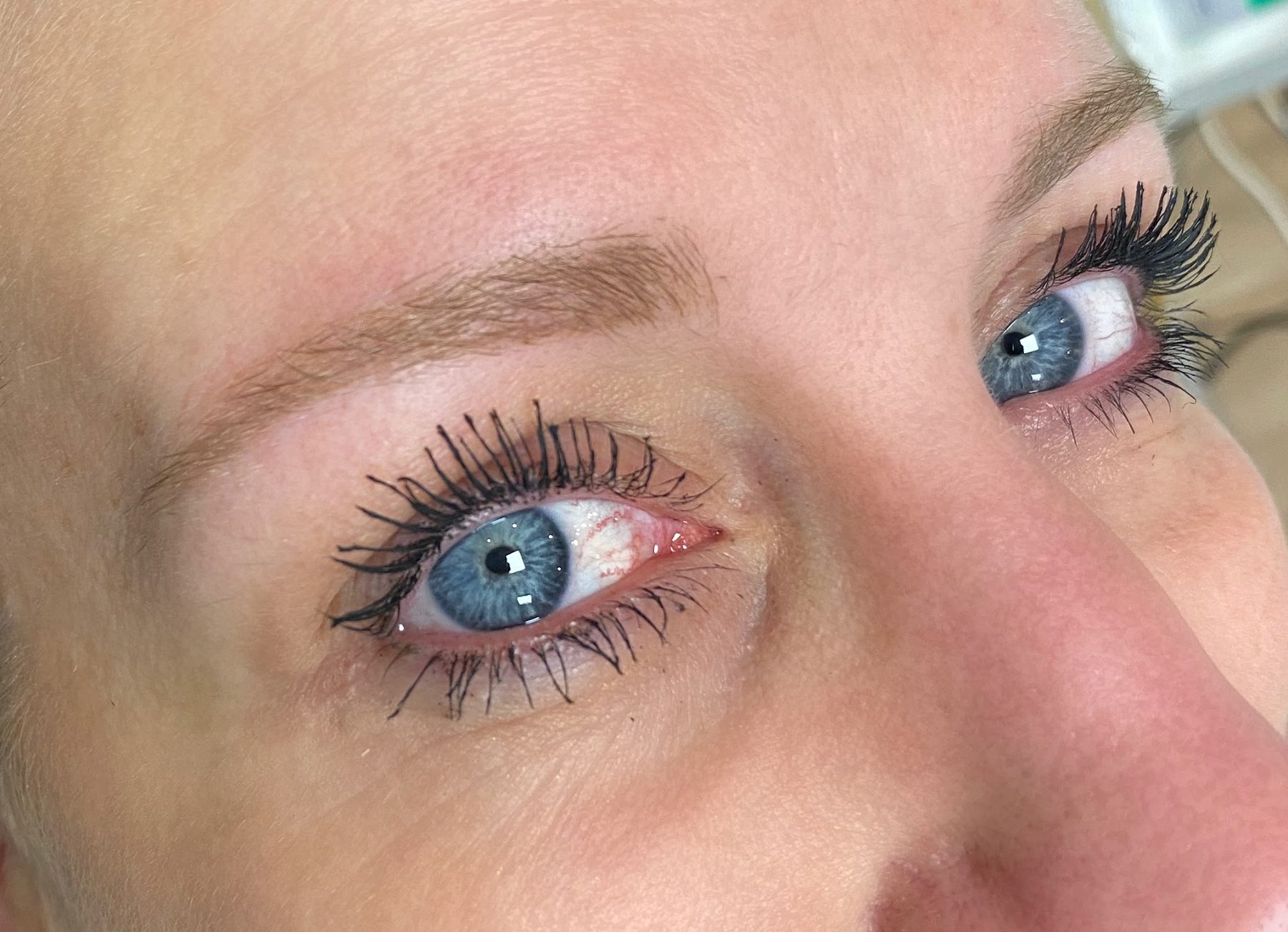 Blauw oog met zachte, natuurlijke wenkbrauwen